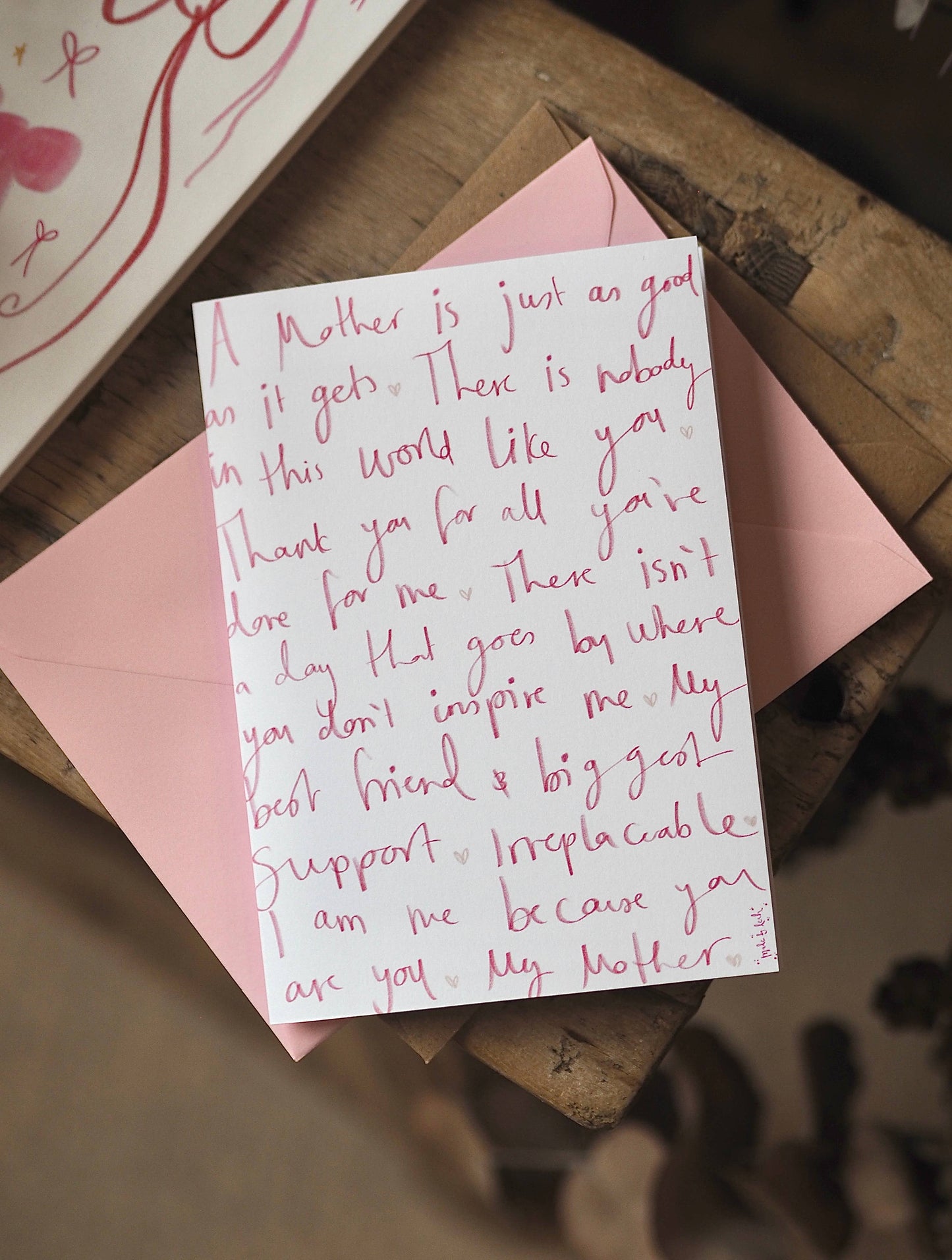 Handwritten card on a pink envelope with a heartfelt message.