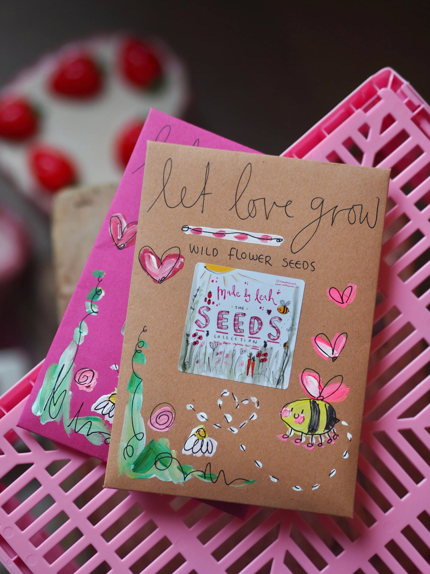 Cardboard seed packet with illustrations and text on a pink surface