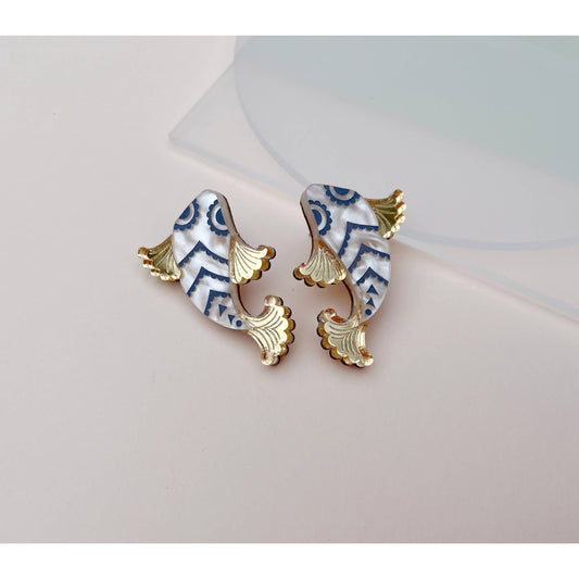 Pair of fish-shaped earrings with gold accents on a light gray background