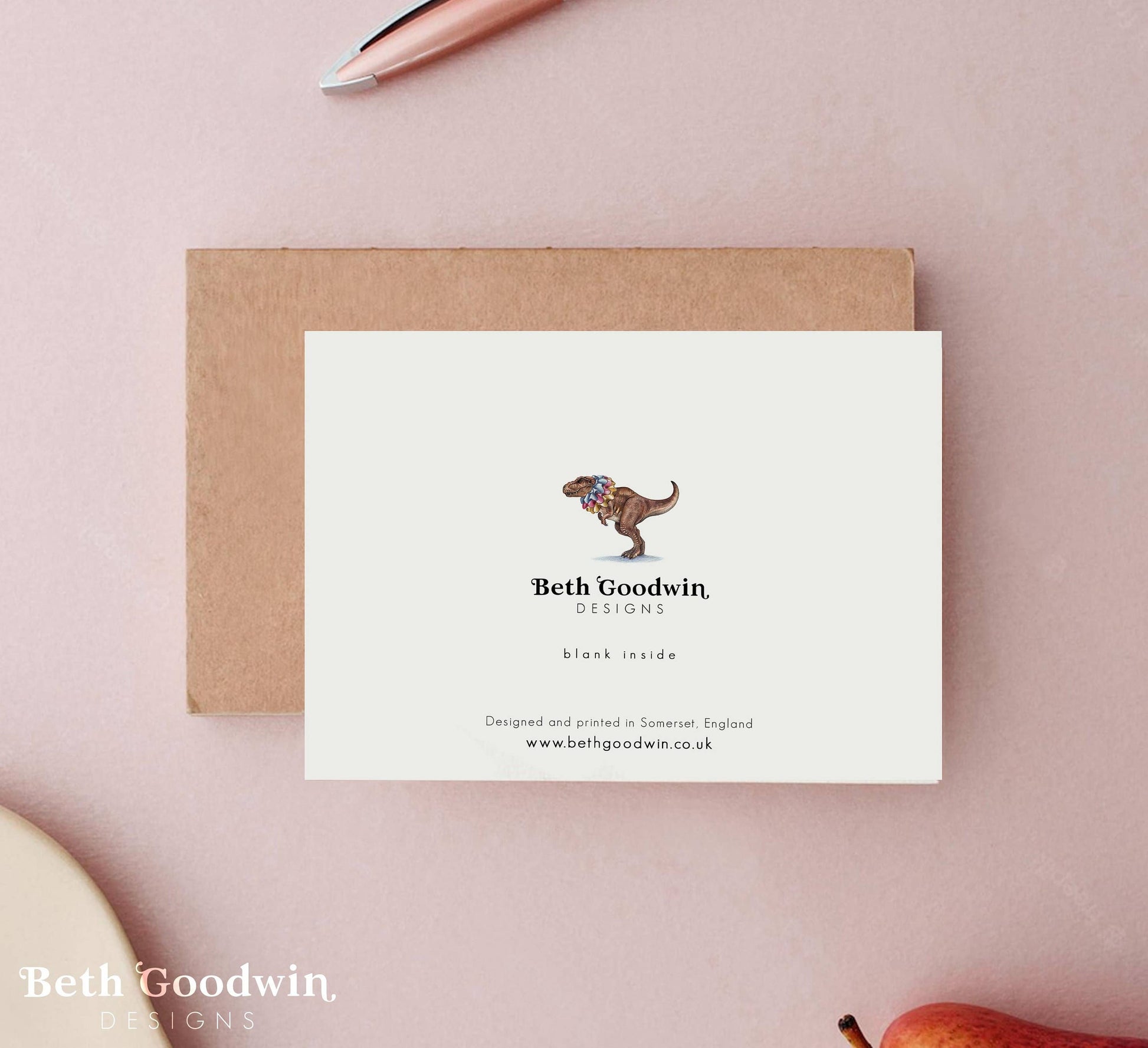 Note card with dinosaur illustration and 'Beth Goodwin Designs' branding on a pink background