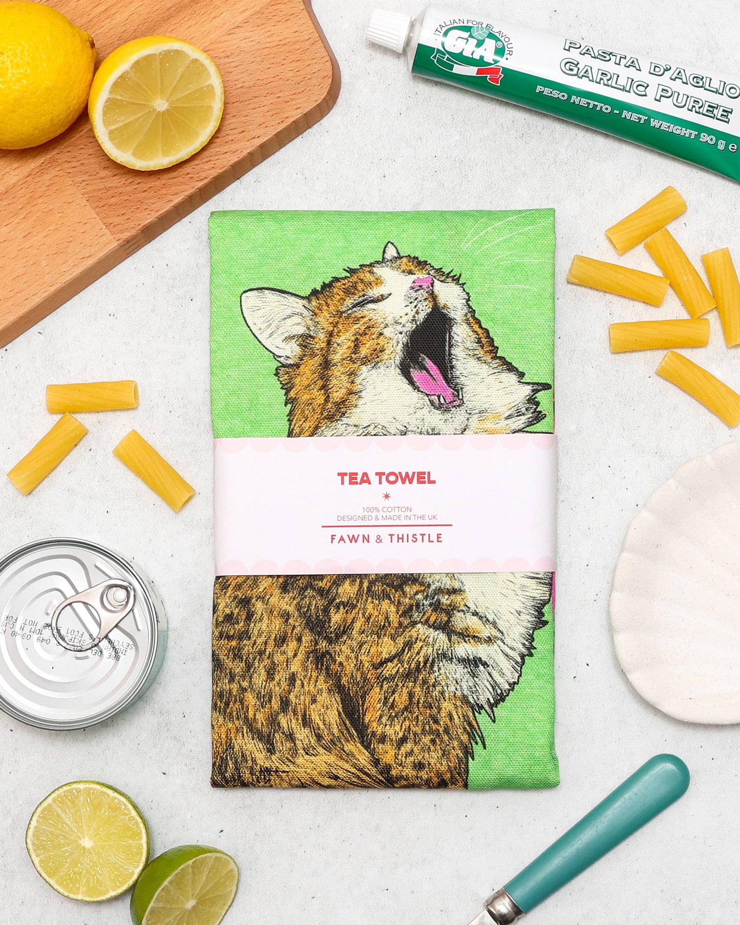 Tea towel with a cat design on a table with pasta and lemons