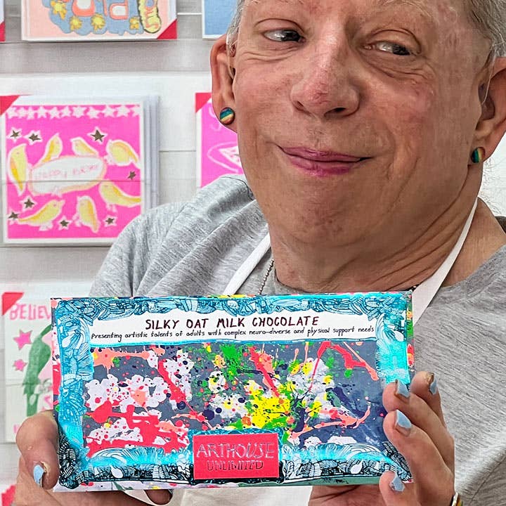 Person holding a box of Silky Oat Milk Chocolate with colorful packaging
