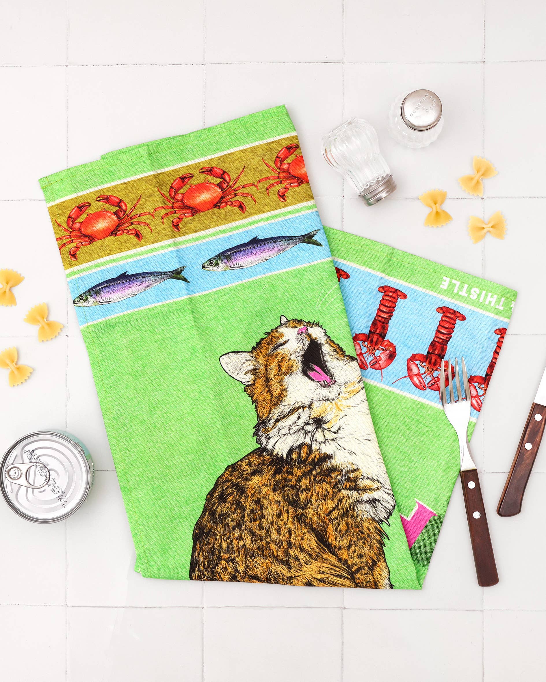 Set of three colorful kitchen towels with different designs on a white surface.