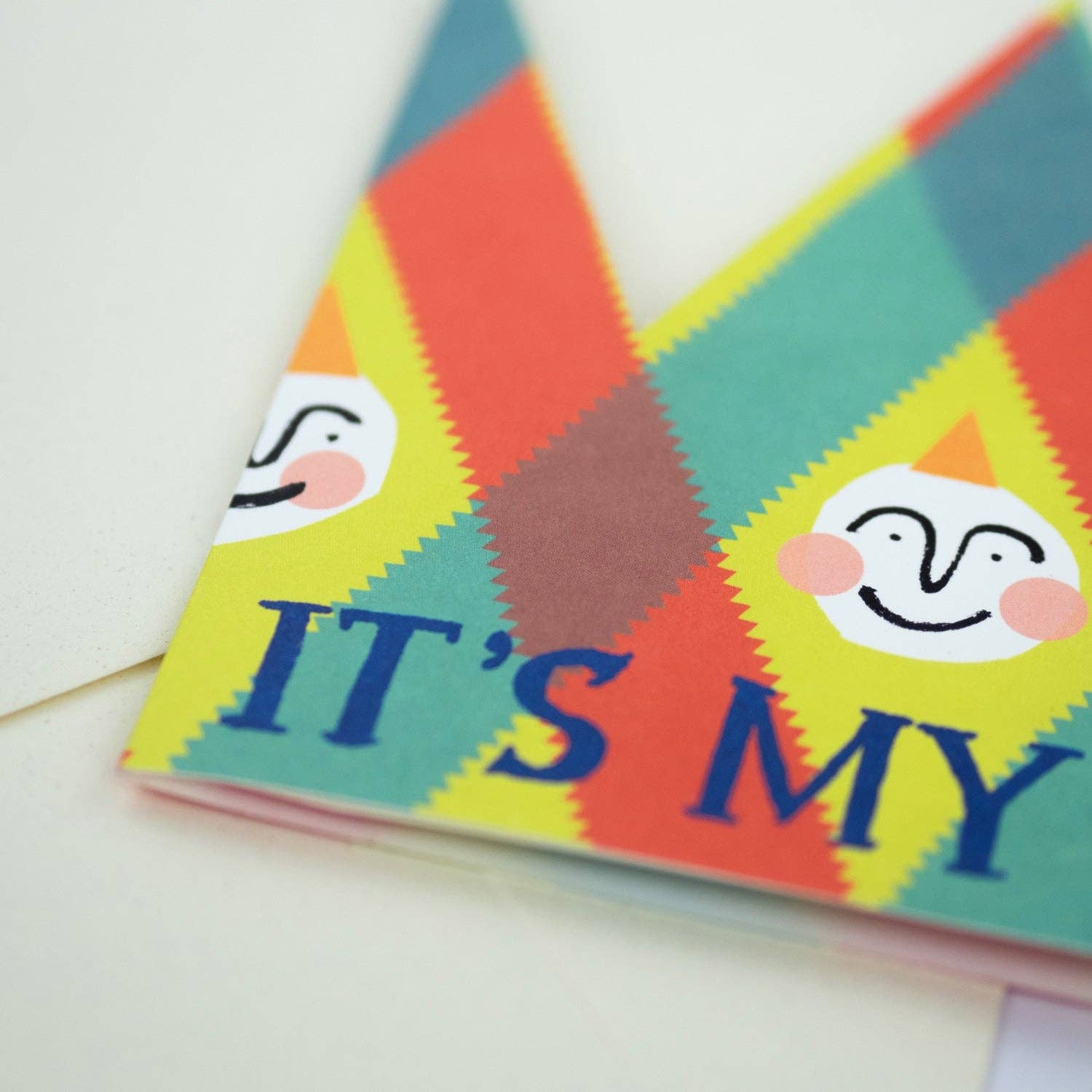 Colorful fabric with smiley faces and text 'IT'S MY' on a white background