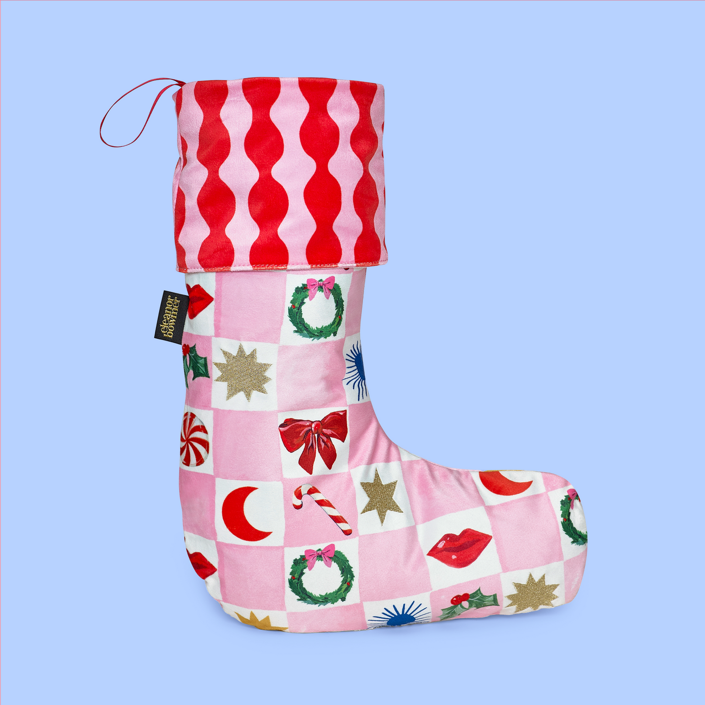 Pink and red patterned Christmas stocking on a light blue background