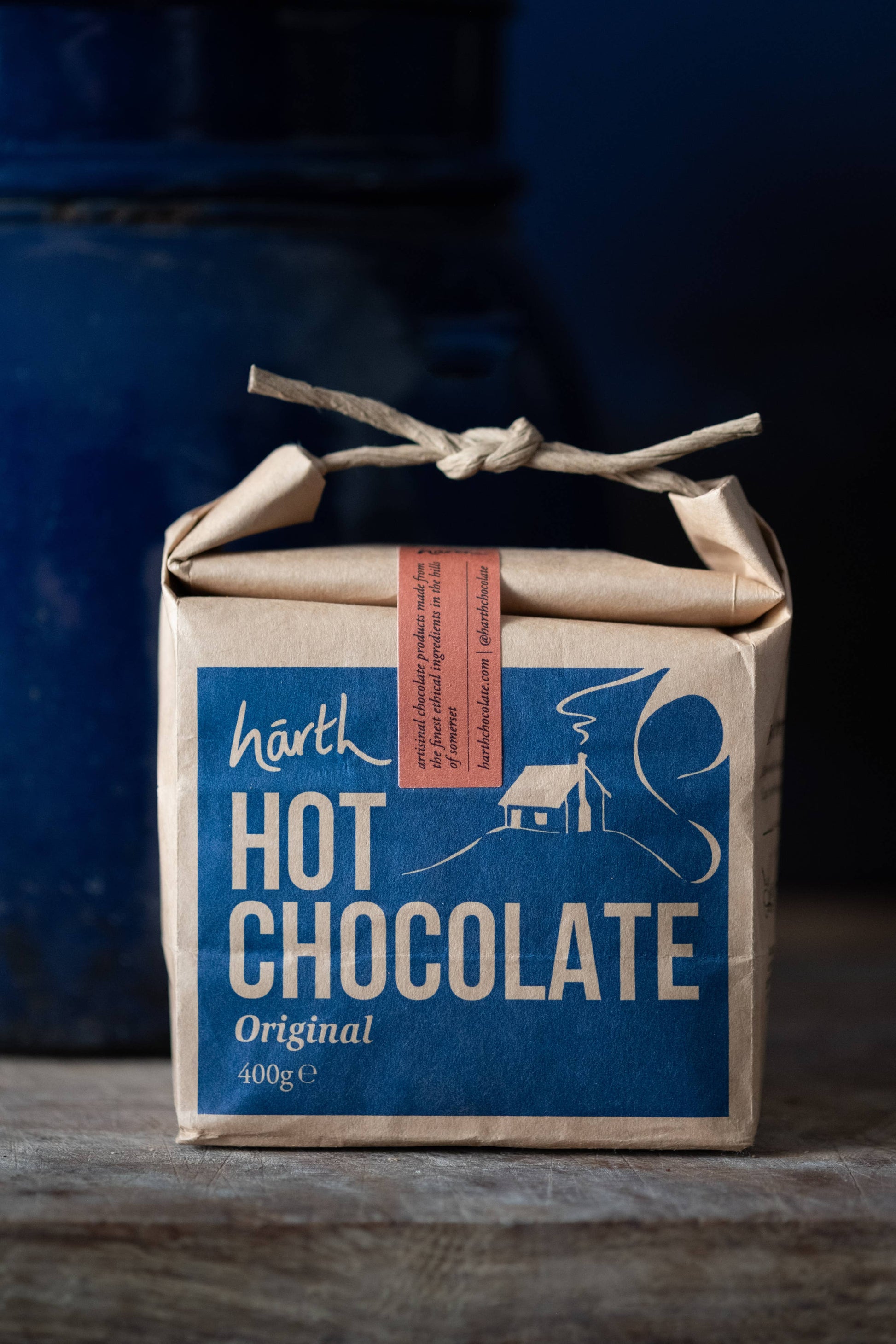 Box of Harth Hot Chocolate with a blue label and brown paper wrapping on a dark background