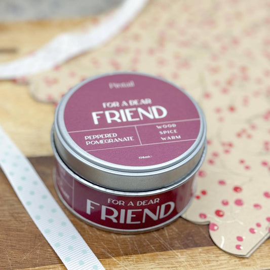 Tin labeled 'For a Dear Friend' on a wooden surface with a polka dot card in the background.