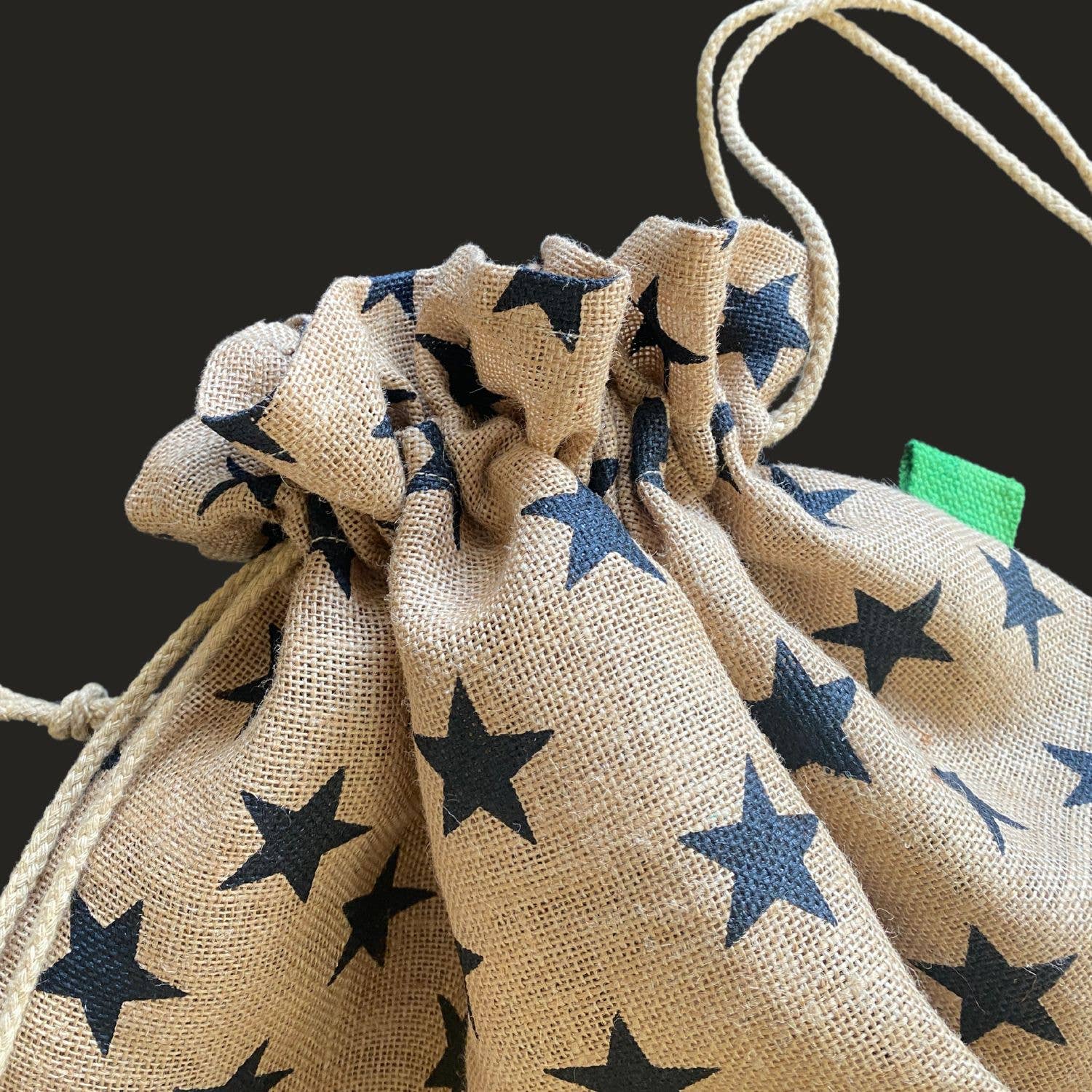 Beige drawstring bags with star patterns on a black background