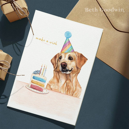 Birthday card with a dog wearing a party hat and birthday cake, on a dark blue surface with brown envelopes.