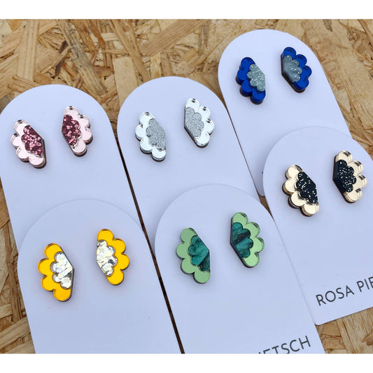 Colorful cloud-shaped earrings on display with a wooden background