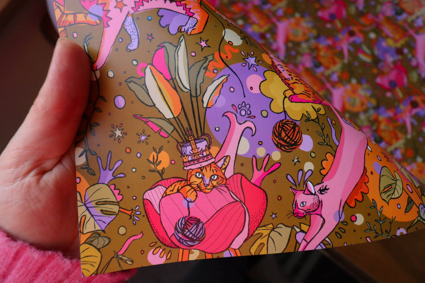 Bright gift wrap featuring cats, plants, feathers and plants.