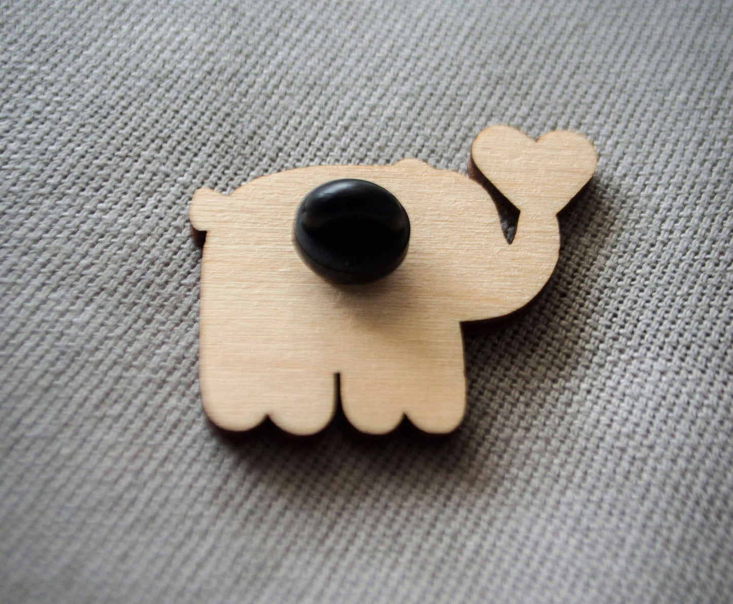 The back of a brightly painted wooden brooch of an art deco inspired blue elephant.
