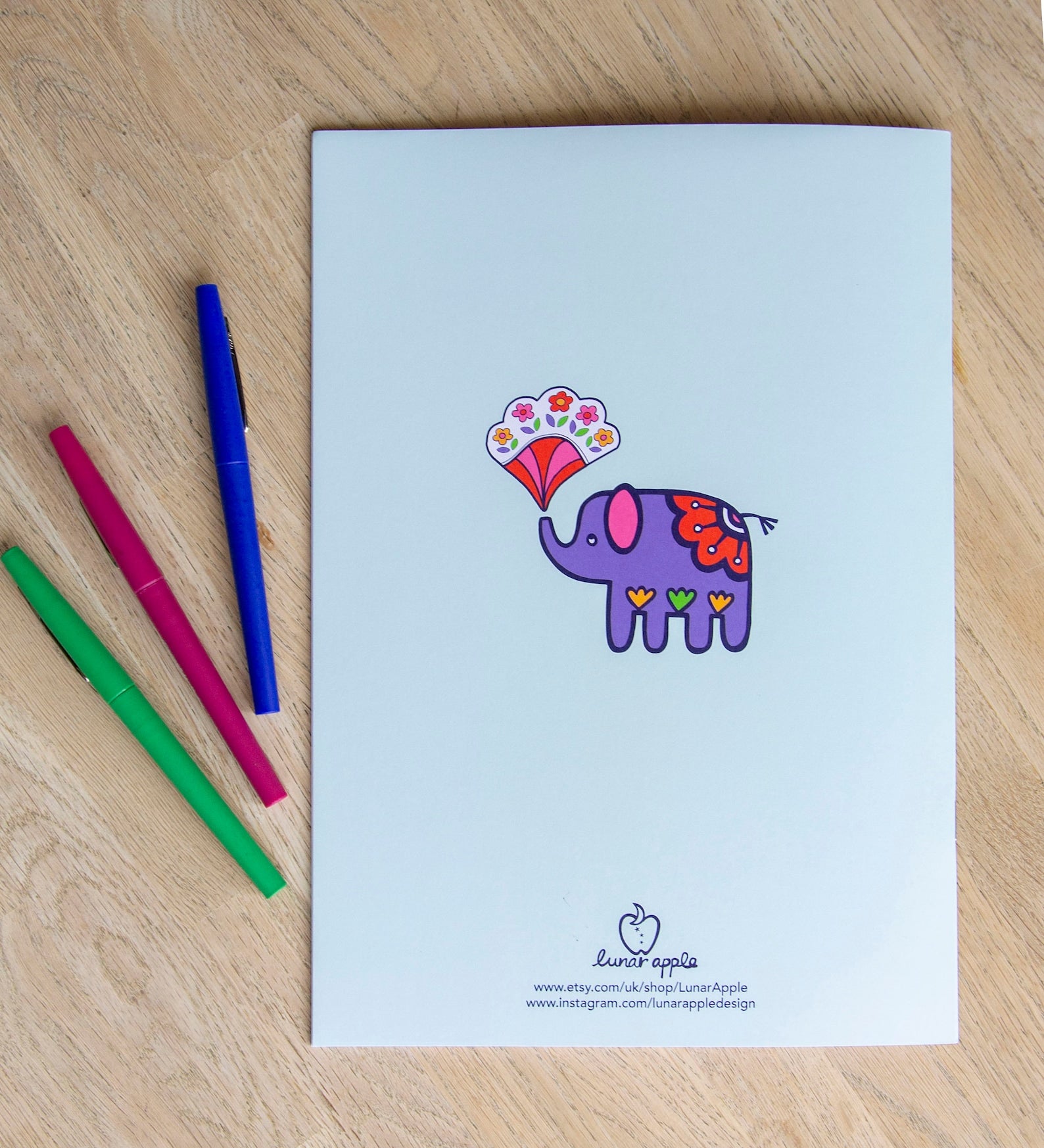 The back cover of a colouring book with a bright purple elephant in the centre.