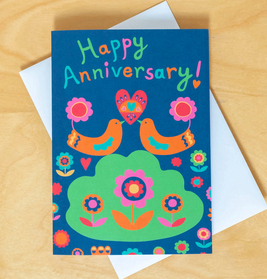 A card depicting two orange art deco birds holding up a heart together with their beaks. Above them reads the text "Happy Anniversary!"