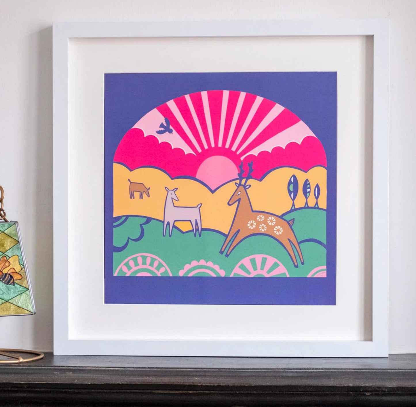 A colourful 2D illustration of art deco style deer with a pink sunset behind them.