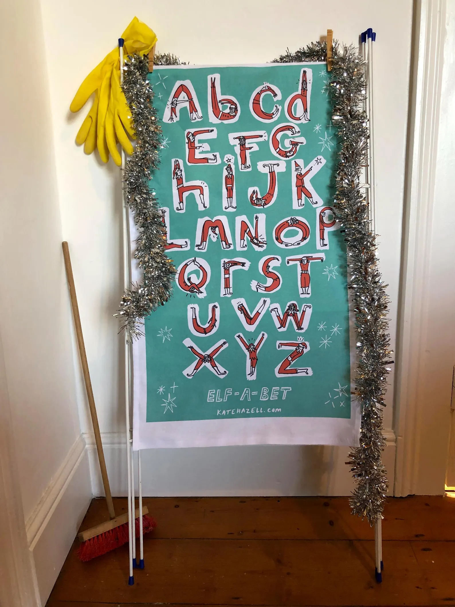 Elves doing letter shapes for the alphabet, green back ground, Tea towel.