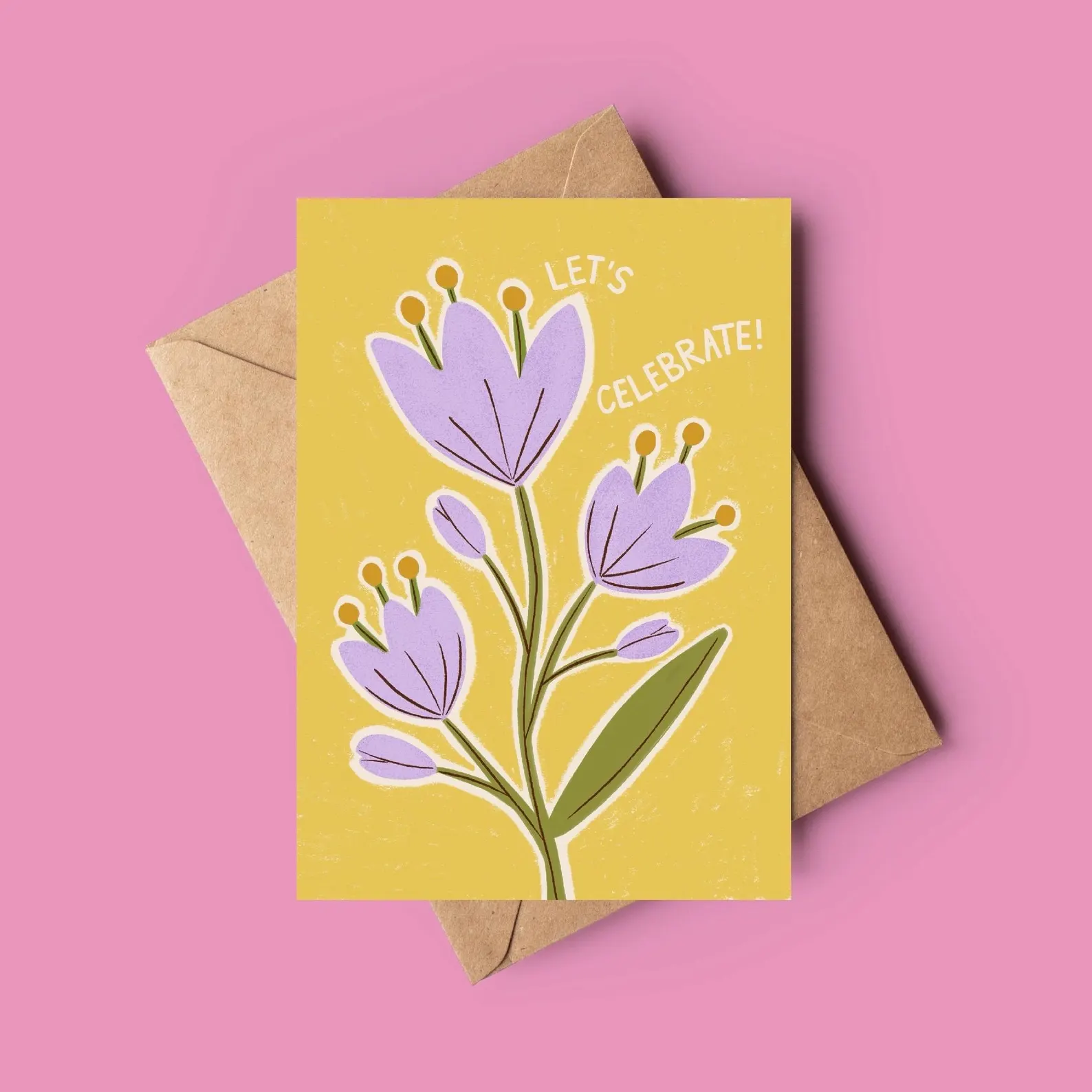 Greeting card with purple flowers and 'Let's Celebrate!' text on a yellow background, with a brown envelope.