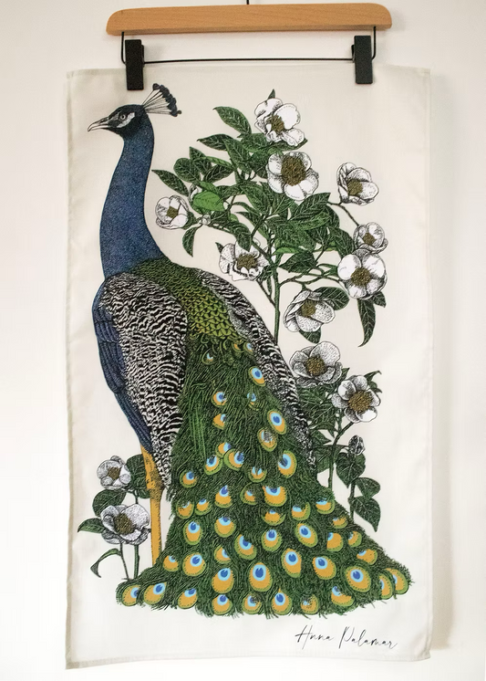 Peacock illustration standing against a camilla flower on a beige background.