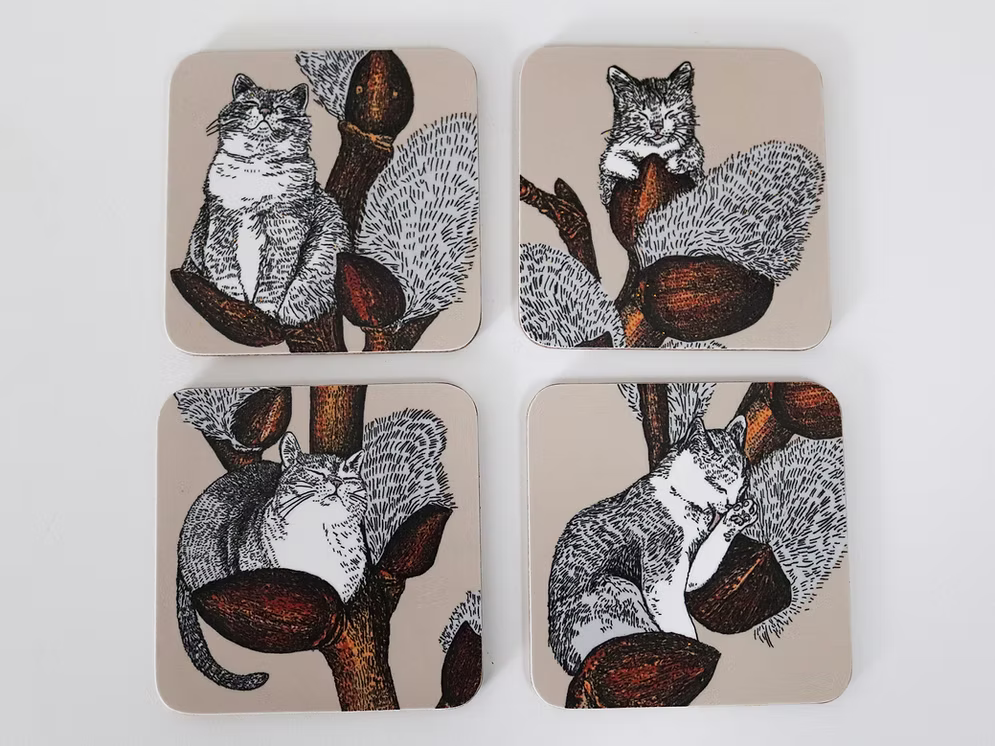 Set of four coasters with cat illustrations on a beige background