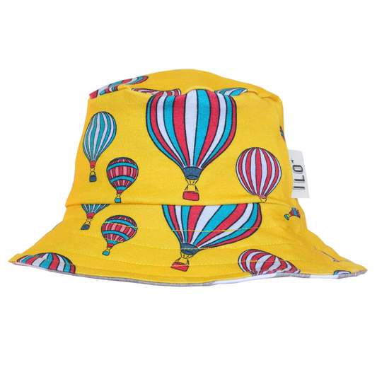 Reversible organic cotton jersey sun hat with balloons on yellow is made in the UK.