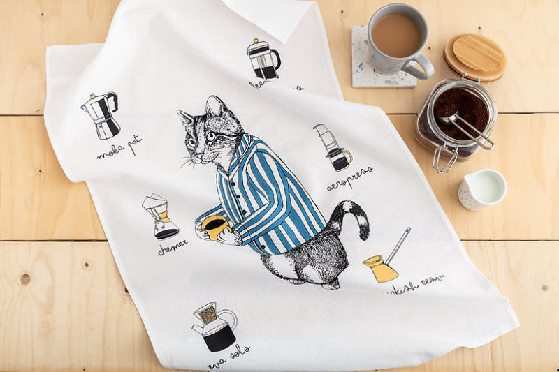 Cat in a striped jacket holding a cup of coffee