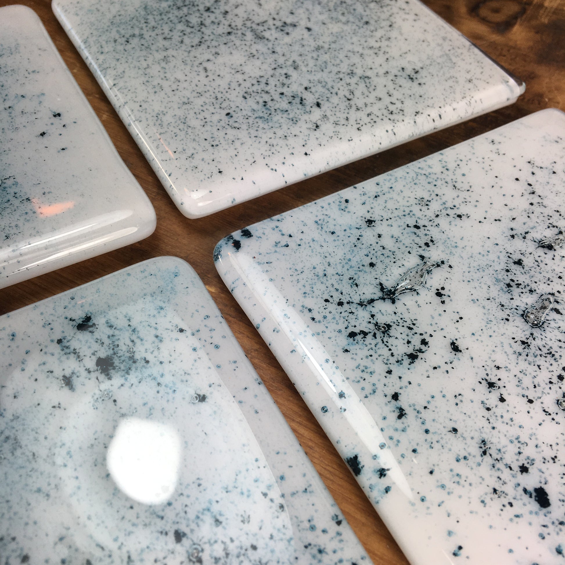 Dadswell Glass, Handmade fused glass coasters, copper oxide powder between glass creating an aqua spray of colour. Beautiful coasters to adorn your home. Made at Glass Designs a Bristol Gift shop.