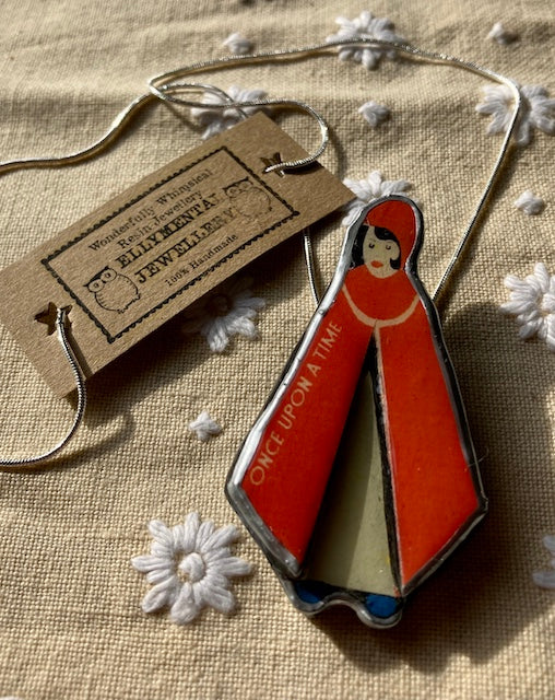 Handmade in Cardiff by layering paper, metal and resin. This pendant is of Little Red Riding Hood with the words Once upon a time on her cape.