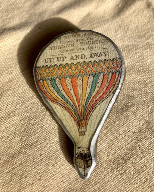 Quirky Victorian style balloon with the text up up and away.  Layered paper, metal and resin, handmade in Cardiff by Ellymental.