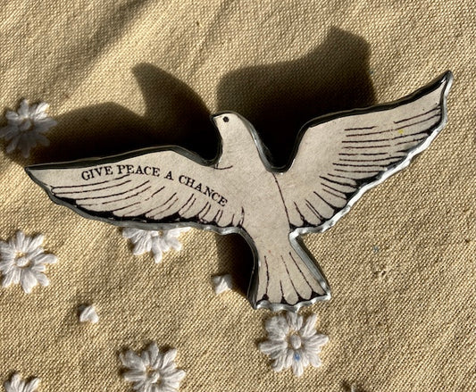 Give Peace a Chance dove brooch.  Made from layered paper and metal with resin to seal. 