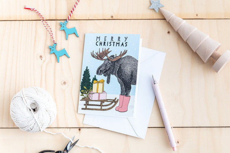 Christmas card with moose and presents and sleigh illustration