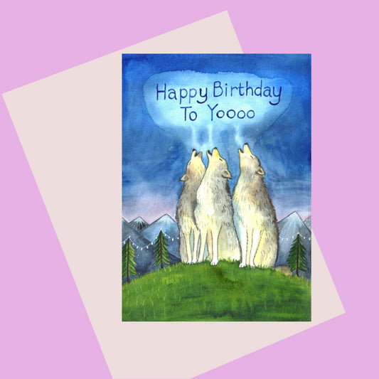 Birthday card with colour illustration of wolves on a hill with mountains behind