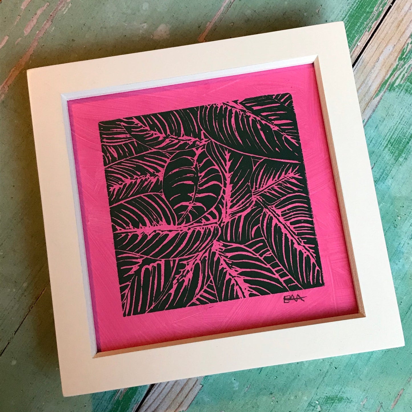 Trelawney Designs hand cut lino print with water based ink. Botanical leaves in Bottle green on a dark pink background.