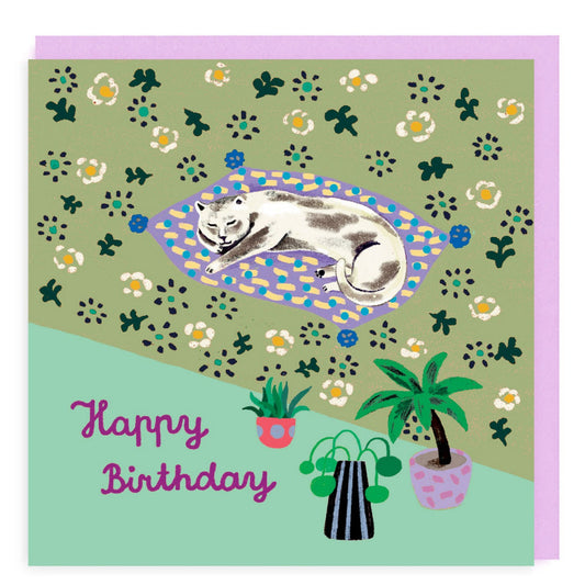 Happy Birthday card with sleeping cat on blanket. Green background with flowers